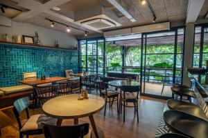 a restaurant with tables and chairs and windows at Abia Villa & Suite Legian in Legian