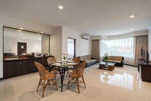 a kitchen and living room with a table and chairs at Bentani Hotel & Residences Cirebon in Cirebon