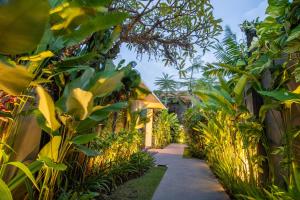a path through a garden with green plants at Abia Villa & Suite Legian in Legian