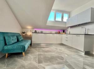 a living room with a green couch and a kitchen at Casa Carletti in Chivasso