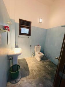 a bathroom with a toilet and a sink and a window at Janaka Villa - Ahangama in Ahangama