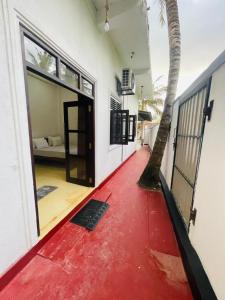 a house with a red floor and a door with a palm tree at Janaka Villa - Ahangama in Ahangama