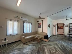 a large living room with a couch and a table at Grey Pearl Homestay in Pondicherry +8 photos