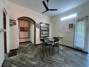 a dining room with a table and a ceiling fan at Grey Pearl Homestay in Pondicherry