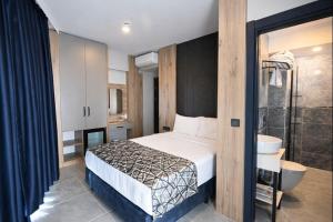 a bedroom with a bed and a bathroom with a shower at Nas Corner Hotel in Antalya