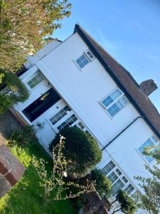 a large white house with windows on it at Garden Lodge, boutique - Walton on Thames in Walton-on-Thames