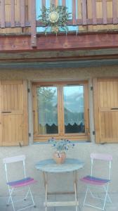 a table with two chairs and a table with a vase on it at La Carline in Guillestre