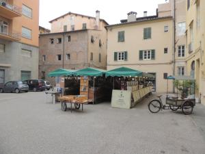 a market with green umbrellas in a parking lot at Al Cardinale Rooms & Studios in Lucca