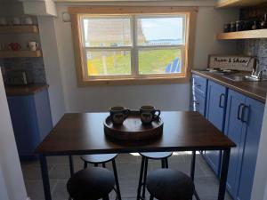 a kitchen with a table with two mugs on it at The Moose Twillingate Island in Twillingate