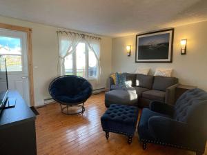 a living room with a couch and a chair at The Moose Twillingate Island in Twillingate