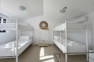 two white bunk beds in a white room at Villa Son Blanc 5 in Sa Caleta +16 photos