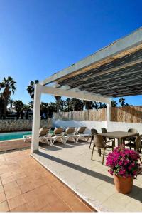 a patio with a table and chairs next to a pool at Villa Son Blanc 5 in Sa Caleta