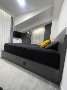 a bedroom with a large bed with yellow pillows at King Size Apartment in Skopje