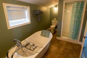 ein Badezimmer mit Badewanne und Fenster und eine Toilette in der Unterkunft Skipper Tom's in Twillingate + 4 Fotos