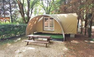 a tent with a picnic table and a bench at Camping le beauvillage Lauzerte in Lauzerte