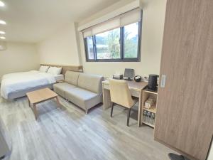 a hotel room with a bed and a desk and a bed and a couch at 悠而行旅 in Nangan