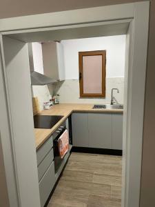 a kitchen with white cabinets and a sink and a mirror at Meri Hause in Vlorë