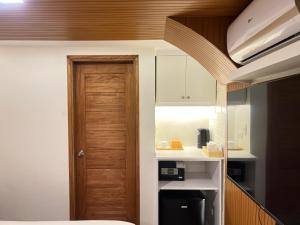 a kitchen with a wooden door in a room at Casa Aya Suites in Puerto Galera
