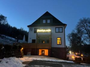ein Gebäude mit einem Schild darauf im Schnee in der Unterkunft frankys cafe in Bärenstein