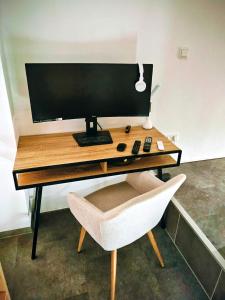 a computer monitor sitting on a desk with a chair at INsight - workcation oldtown in Ingolstadt