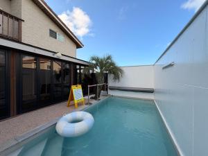 a swimming pool with a sign in front of a house at Arche House B in Jeju