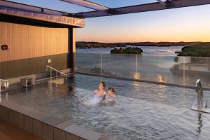 a woman and a child in a hot tub on a building at Ooedo Onsen Monogatari Premium Shima Saichoraku in Shima