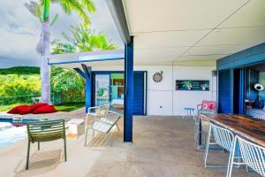 a patio with chairs and a table next to a pool at LA MAISON DES JADES in La Saline les Bains