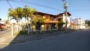 un edificio al lado de una calle con palmeras en Residencial Vó Maria, en Florianópolis