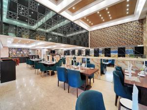 a restaurant with blue chairs and tables in a room at Palette Orient Hotel & Convention Centre by CheckIn, Nagpur in Nagpur