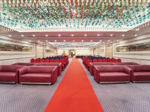 a large room with red chairs and a red carpet at Palette Orient Hotel & Convention Centre by CheckIn, Nagpur in Nagpur