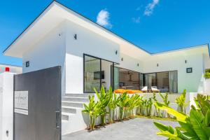 a white house with plants in front of it at Villa Laura 2Br & Private Pool in Mae Nam in Mae Nam