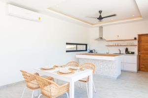 a white kitchen with a white table and chairs at Villa Laura 2Br & Private Pool in Mae Nam in Mae Nam