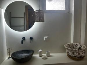 a bathroom with a round mirror and a chair on a counter at Petrino Minimal in Dhéndra +55 photos