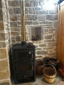 a stone fireplace with a black stove in a room at Petrino Minimal in Dhéndra