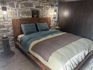 a bedroom with a large bed in a stone wall at Petrino Minimal in Dhéndra