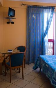 een slaapkamer met een tafel, een bed en een raam bij Hotel Nizza in Nizza di Sicilia