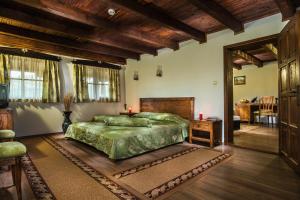 a bedroom with a green bed and a wooden ceiling at Elenski Riton Complex in Sredni Kolibi