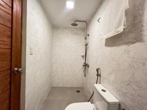 a white bathroom with a toilet and a shower at Casa Aya Suites in Puerto Galera +52 photos
