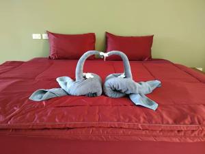 two stuffed swans sitting on top of a bed at Spy Home apartment in Khao Lak