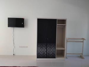 a black cabinet with a tv on a wall at Spy Home apartment in Khao Lak