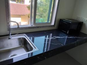 a kitchen counter with a sink and a microwave at Spy Home apartment in Khao Lak +6 photos