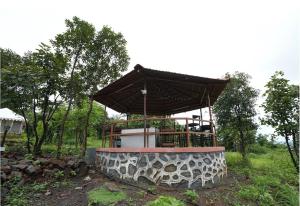 a building with an umbrella on top of it at Gaudham Periyar Farms in Jambhulpāda