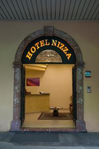 een toegang tot een hotel needer met een tafel erin bij Hotel Nizza in Nizza di Sicilia