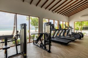 a gym with a row of treadmills and ellipticals at Cocoon Maldives - All Inclusive in Lhaviyani Atoll