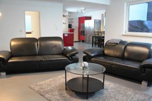 a living room with two leather couches and a table at Rooftop Apartment in Norderstedt
