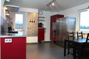 a kitchen with red cabinets and a table with a dining room at Rooftop Apartment in Norderstedt