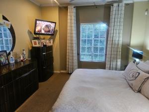 a bedroom with a bed and a television in it at 20 in Crescent in Gqeberha