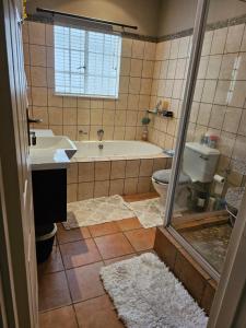 a bathroom with a tub and a toilet and a sink at 20 in Crescent in Gqeberha +18 photos