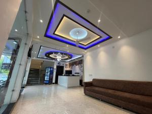 a lobby with a couch and a blue ceiling at Hotel Ashok Palace in Agra