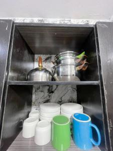 a shelf with a bunch of cups and a pot at 6c Apartment in Port Harcourt
